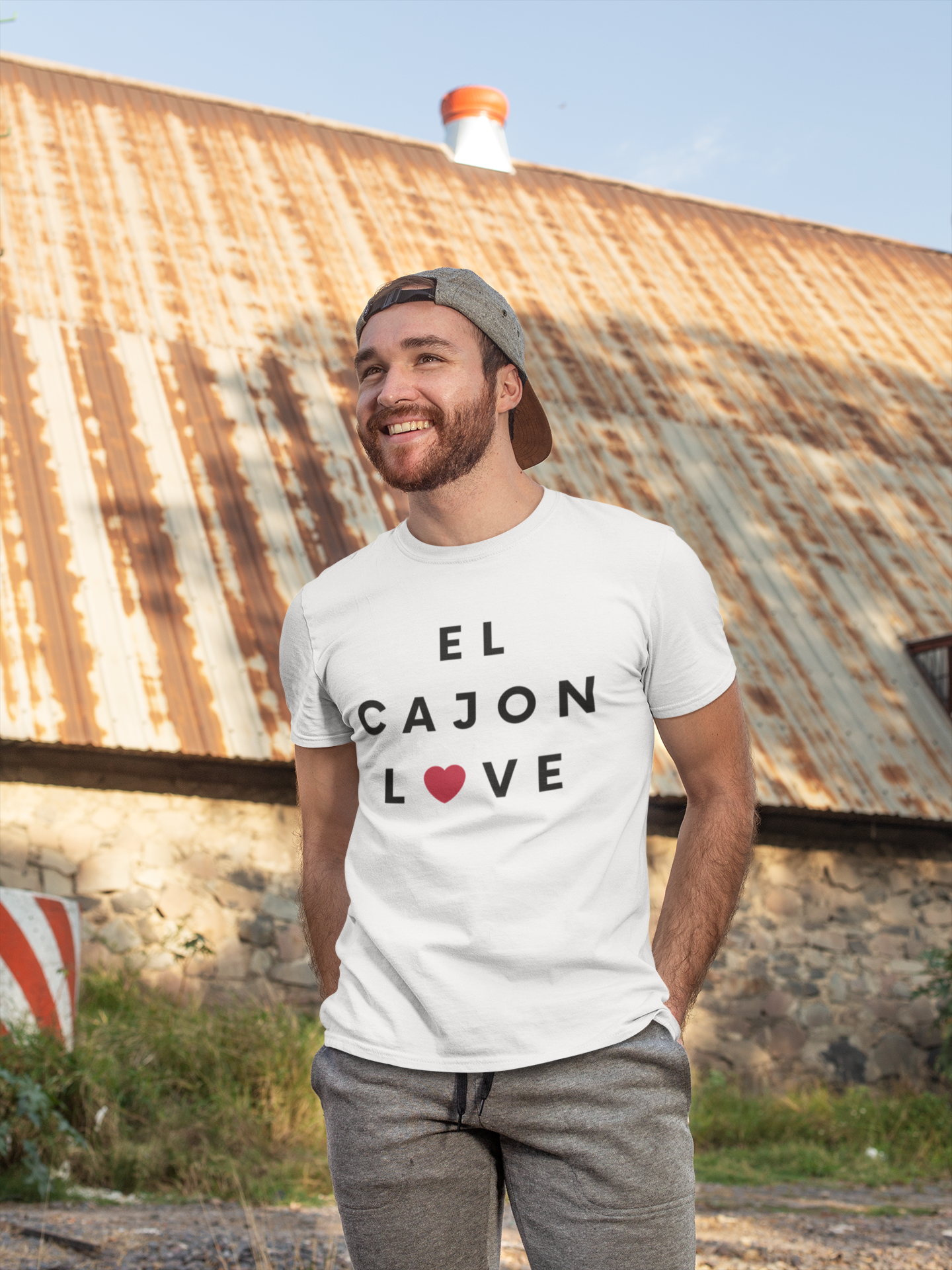 Happy man standing in front of old building wearing an El Cajon lovr t-shirt.