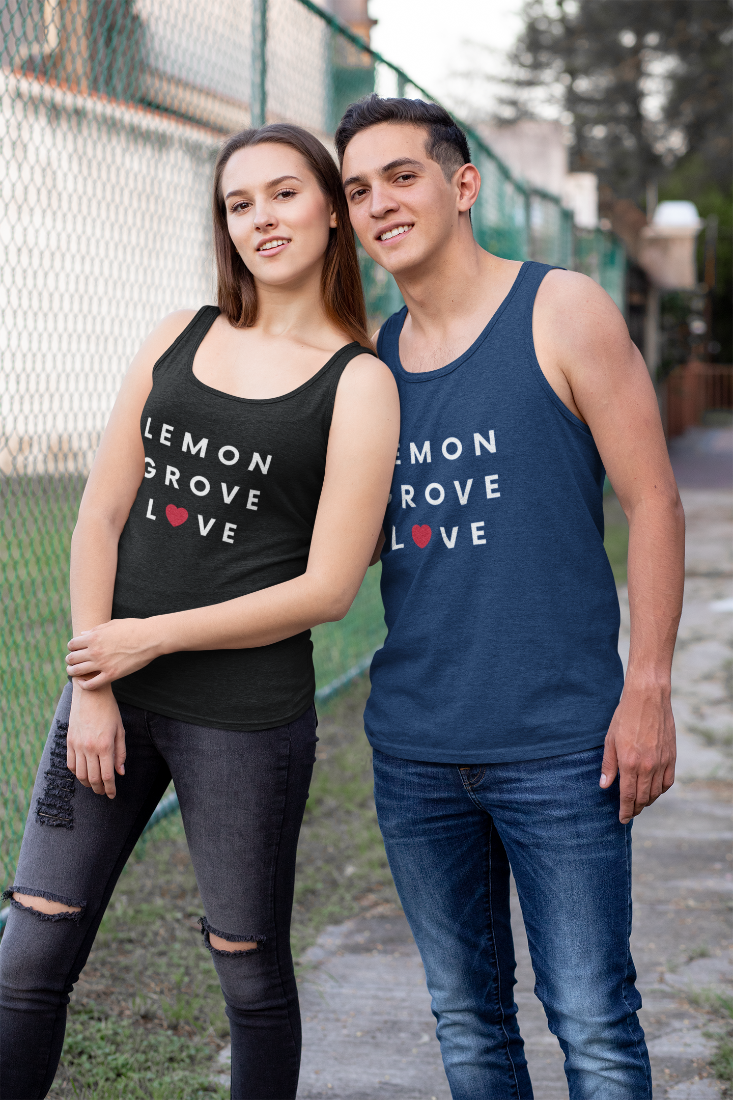 Couple standing outside a park wearing matching Lemon Grove tank-tops.