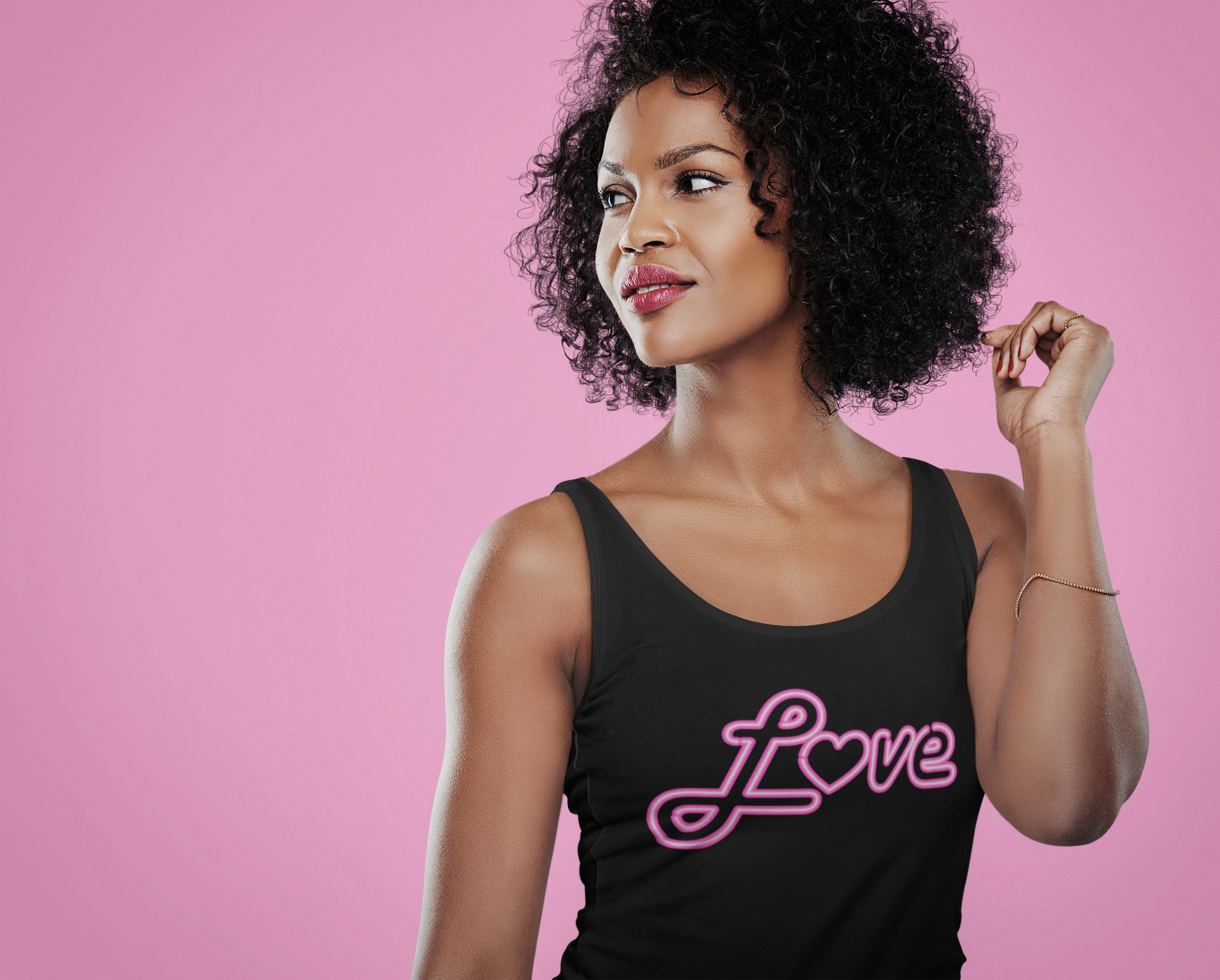 Curly hair black woman wearing black tank-top with pink neon love sign.