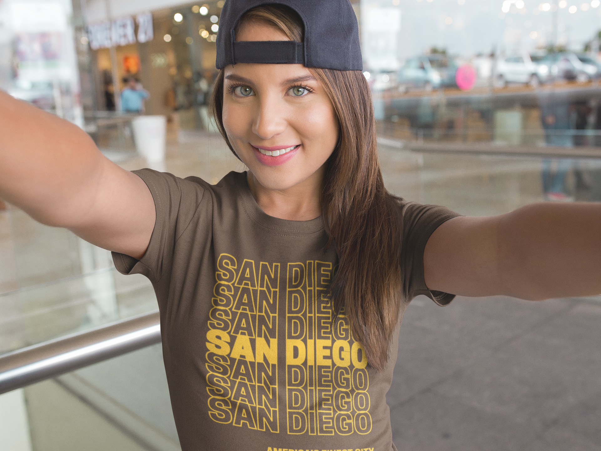 Smiling woman taking a selfie wearing a brown and gold San Diego t-shirt.